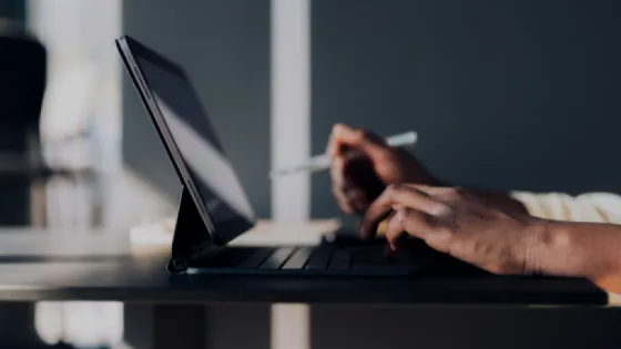 Close-up of a person's hands working at a tablet computer